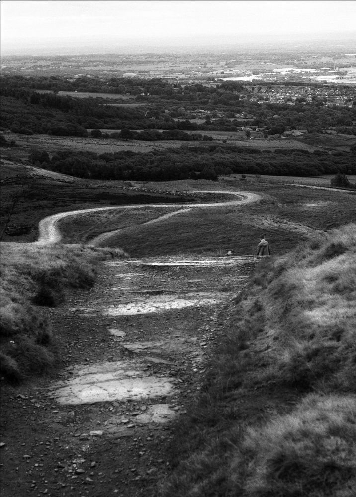 Black and white picture of the view of a path down a hillside.