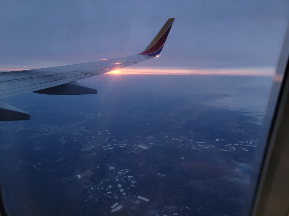 the sunset over Atlanta, Georgia outside the window of the plane-the sunset crests with the horizon 