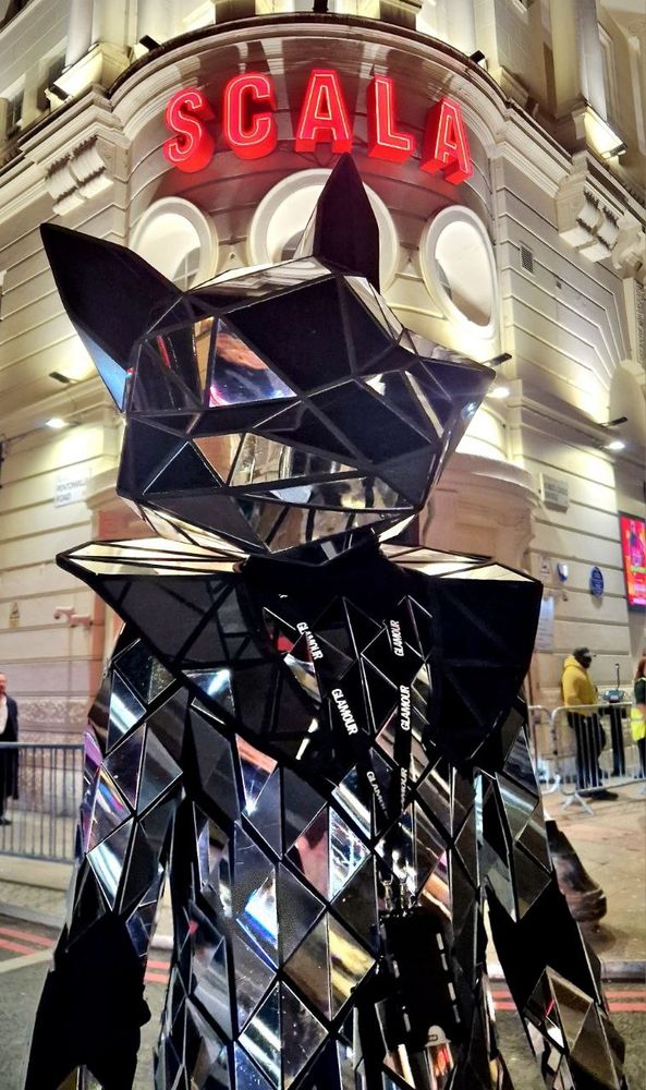 A mirrored fox posing under the sign for Scala in London
