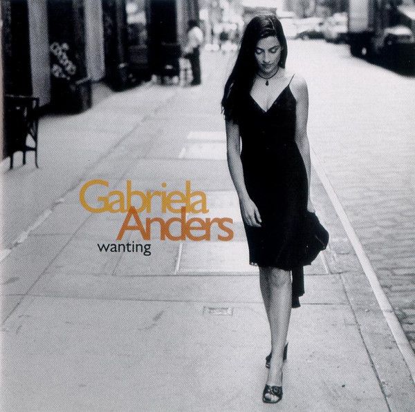 Cover art of Gabriela Anders' album "Wanting".  Image of her walking on a sidewalk in a black dress and heeled sandals.