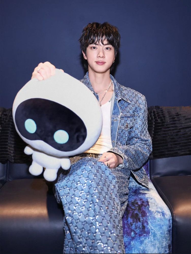 Seokjin sitting on the couch, holding Wootteo out