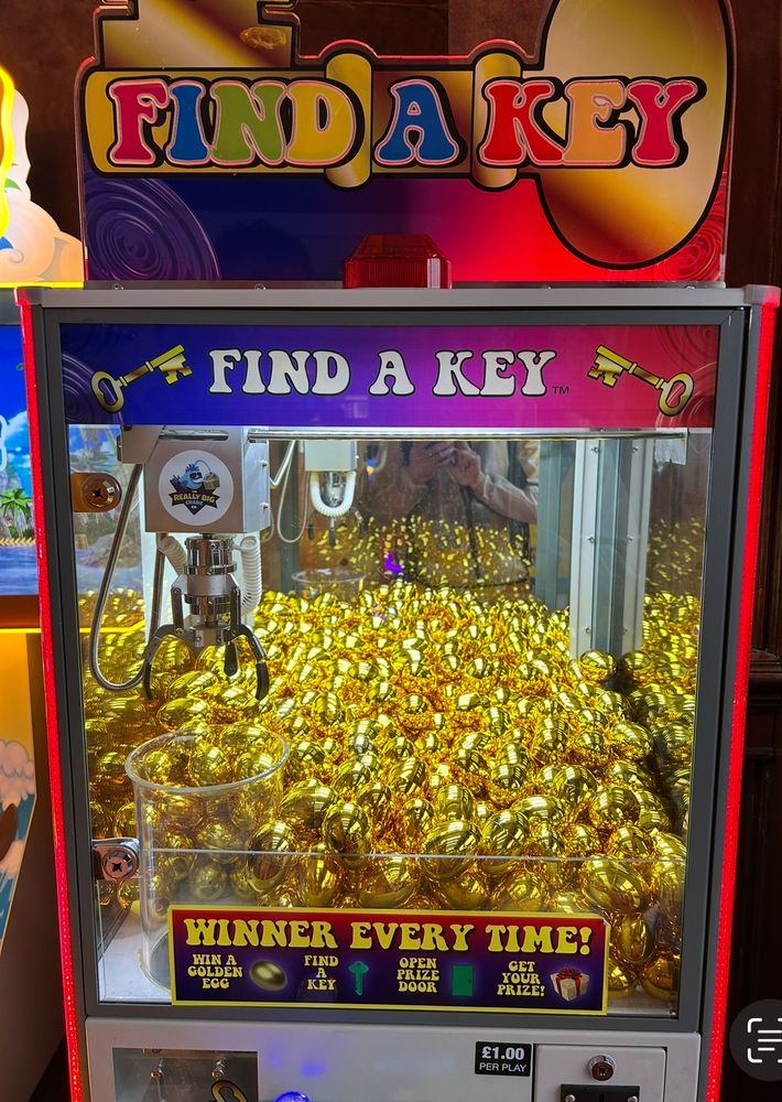 An image of a grab machine filled with golden coloured plastic eggs.
