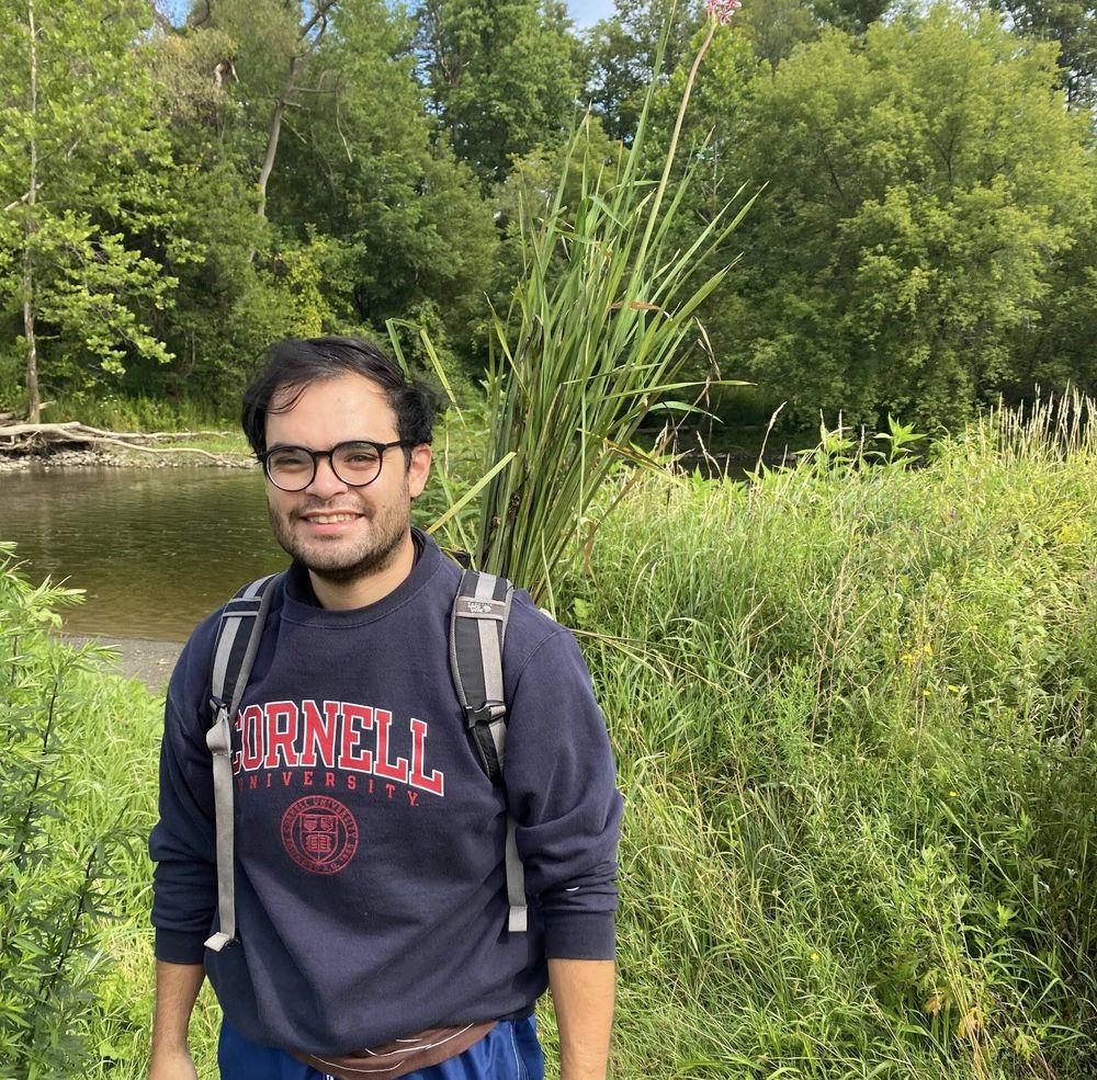 A photo of speaker Jesus Martinez-Gomez by a river with lots of plants around.