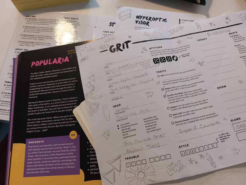A book with black, purple and yellow sections is partially obscured by a Slugblaster character sheet covered in doodles including the cool S and the fast forward symbol