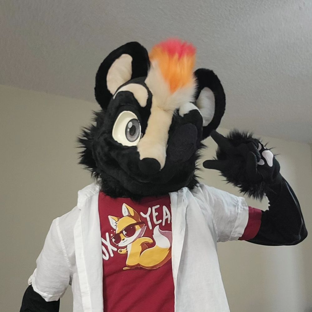 Tech in a red Fox Yeah Tee Turtle shirt, with a white button up short sleeve dress shirt posing with a wink and peace sign.