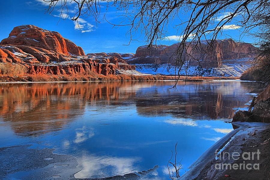 Red rock formations reflect in the Green River near the town of Moab, not too far from the well known national parks on Arches and Canyonlands.  Photo by Adam Jewell.  Buy prints, puzzles, blankets and more at AdamJewell.com