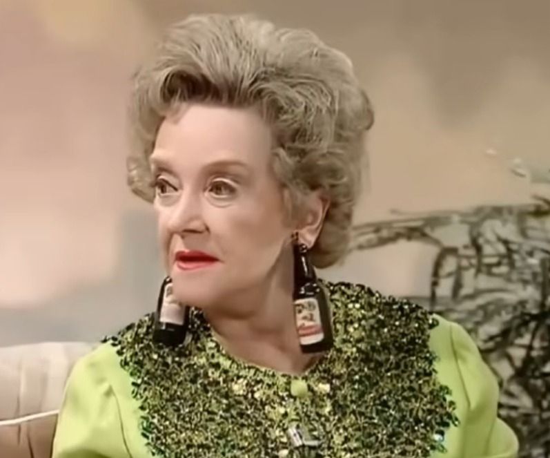 Beryl Reid wearing beer bottle earrings