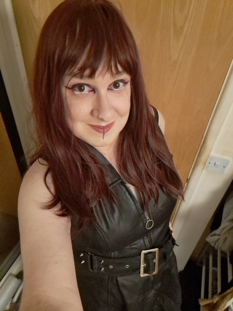 Red headed goth woman in a leather dress