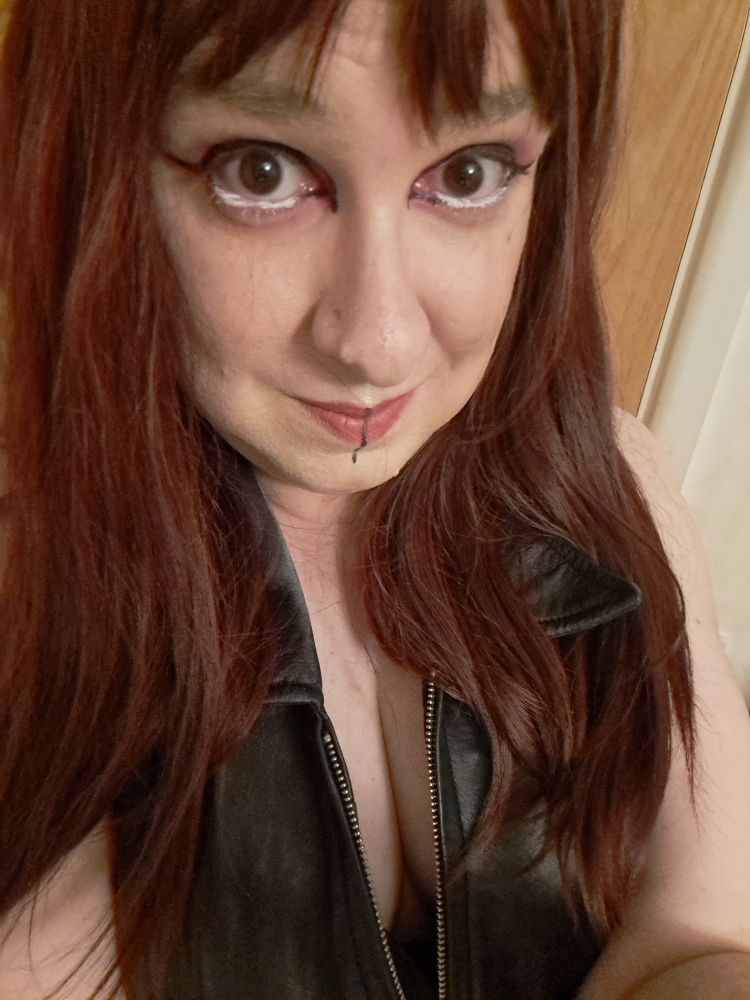 Red headed goth woman in a leather dress