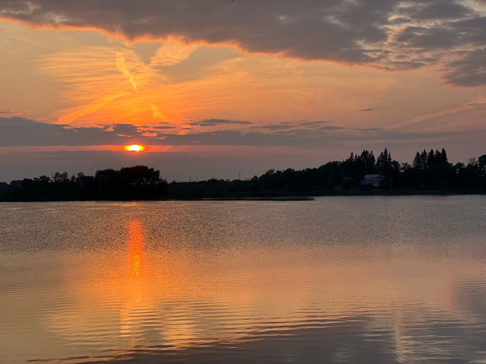 Sunset over a lake with blue and orange and peach tones.  There are ripples on the water