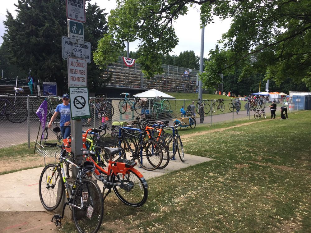 Picture showing full bike racks and bikes parked against fences. 