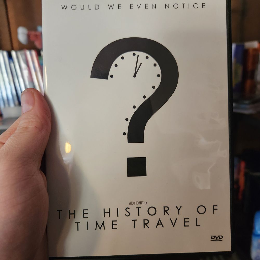 The picture is of the movie The History of Time Travel.  The title of the movie is at the bottom, with a question mark in the middle, and the words "Would we even notice?" at the top.