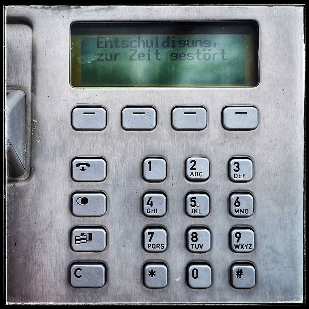 Ein Tastenfeld eines Münzfernsprechers. In dem Sichtfenster steht Entschuldigung, zur Zeit gestört 