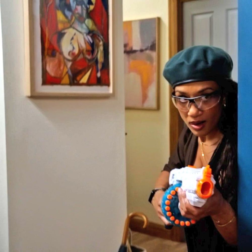 Remi with a NERF gun. The wall art in question is next to her on the, uh, wall