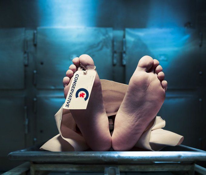 A picture of a corpse lying in a morgue drawer with a toe tag that says "Conservative" and has the logo of the Conservative Party of Canada.