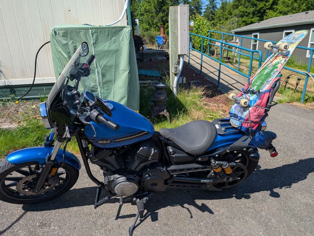 Blue motorcycle with my backpack and skateboard