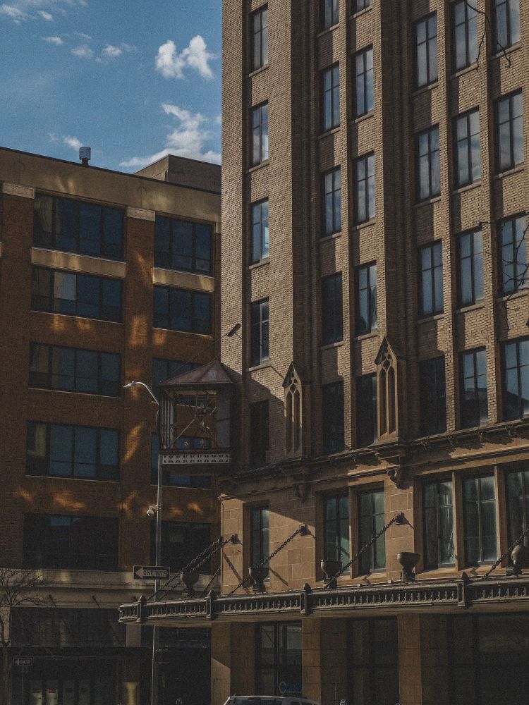 A photograph of a seemingly un-occupied building in a downtown environment, edited with warmer tones and a grain effect.