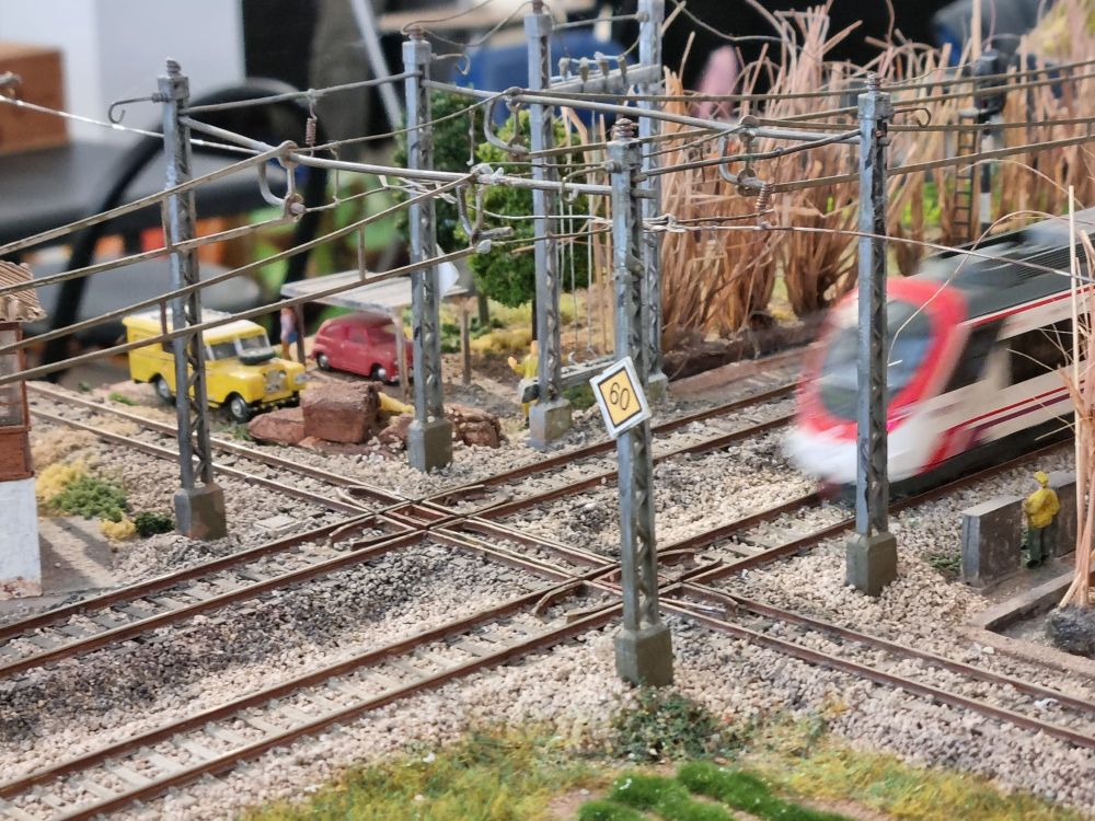 Foto de una sección de la maqueta. Es una recreación del cruce a nivel de las vías de ferrocarril convencional con la vía de ancho métrico del trenet en La Cadena, Valencia