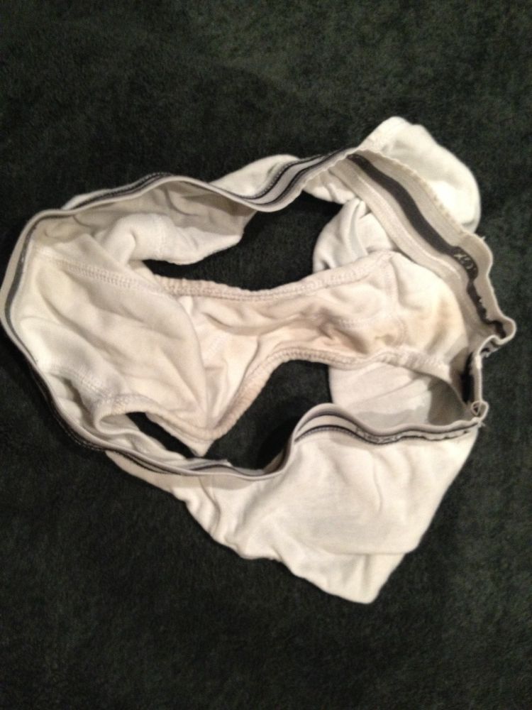 A pair of white next briefs lying on a dark blue carpet