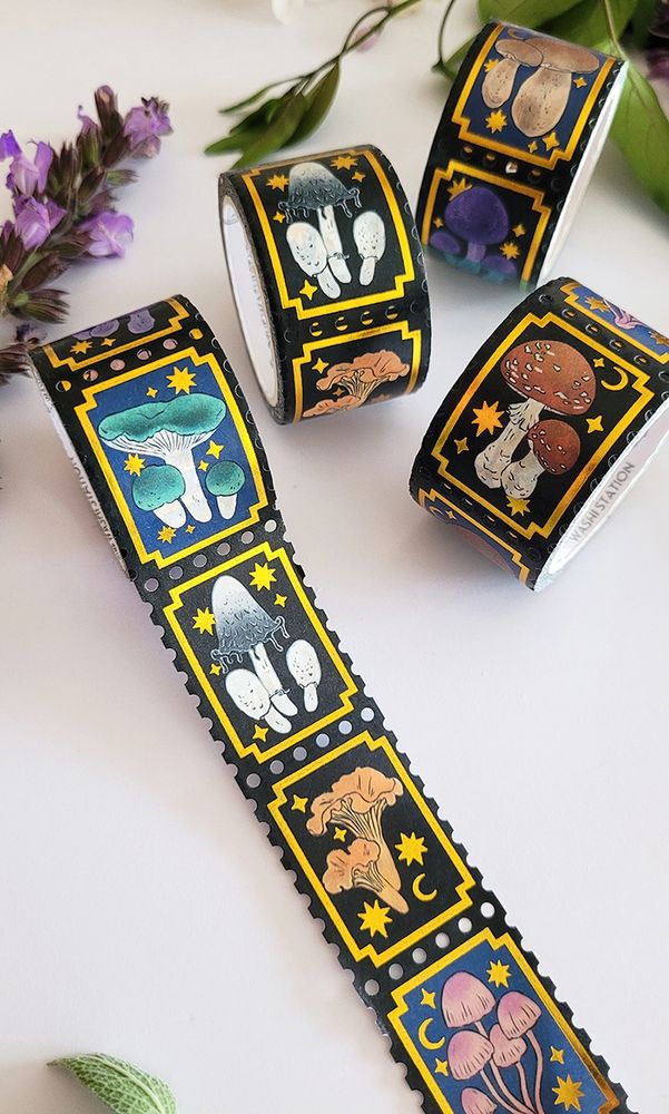 black stamp washi tape with gold decorative foil shaped in a frame and stars. each stamp segment has a different mushroom.