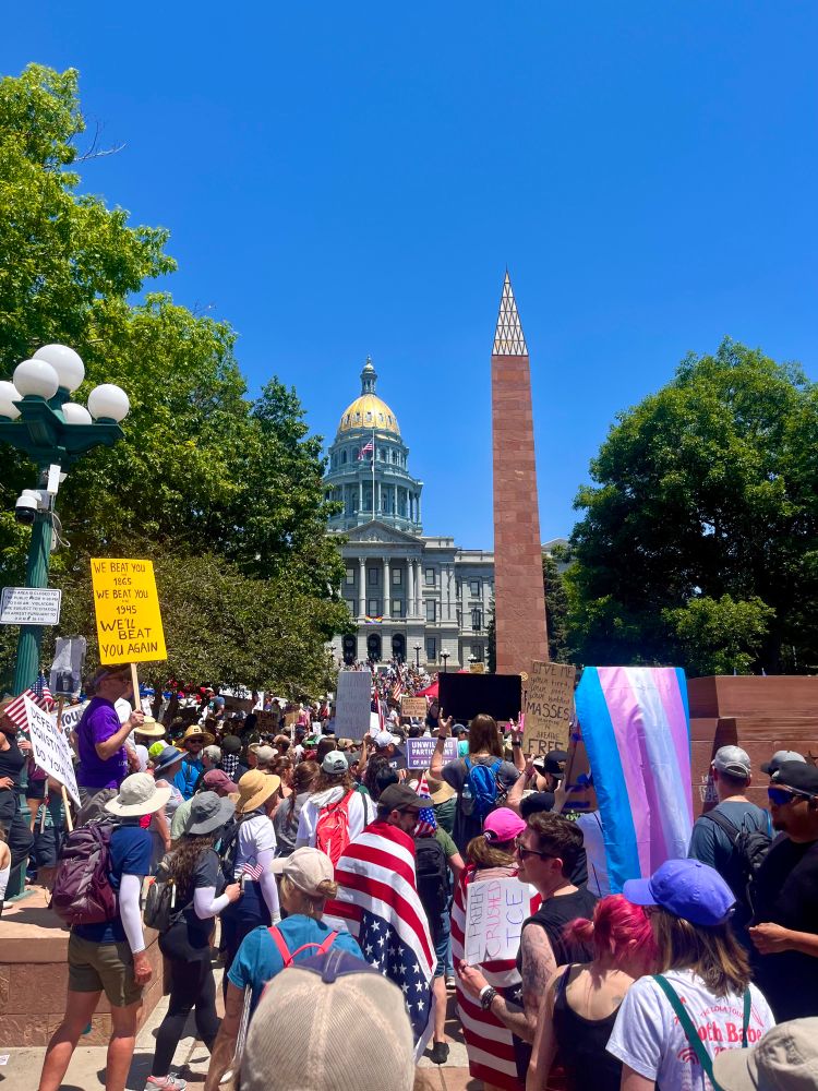 Denver capitol building with large crowd of people protesting