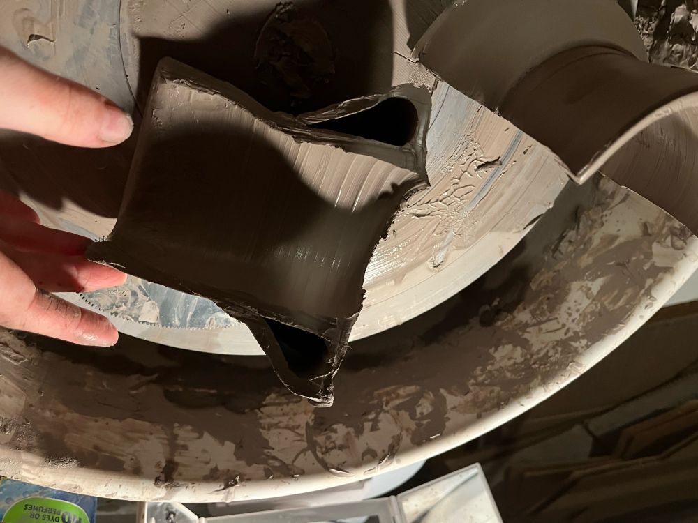 Cross-section of half a stoneware vessel which is internally cylindrical. An angled section extends for half the height of the cylinder and there is a pocket of air between the parts.