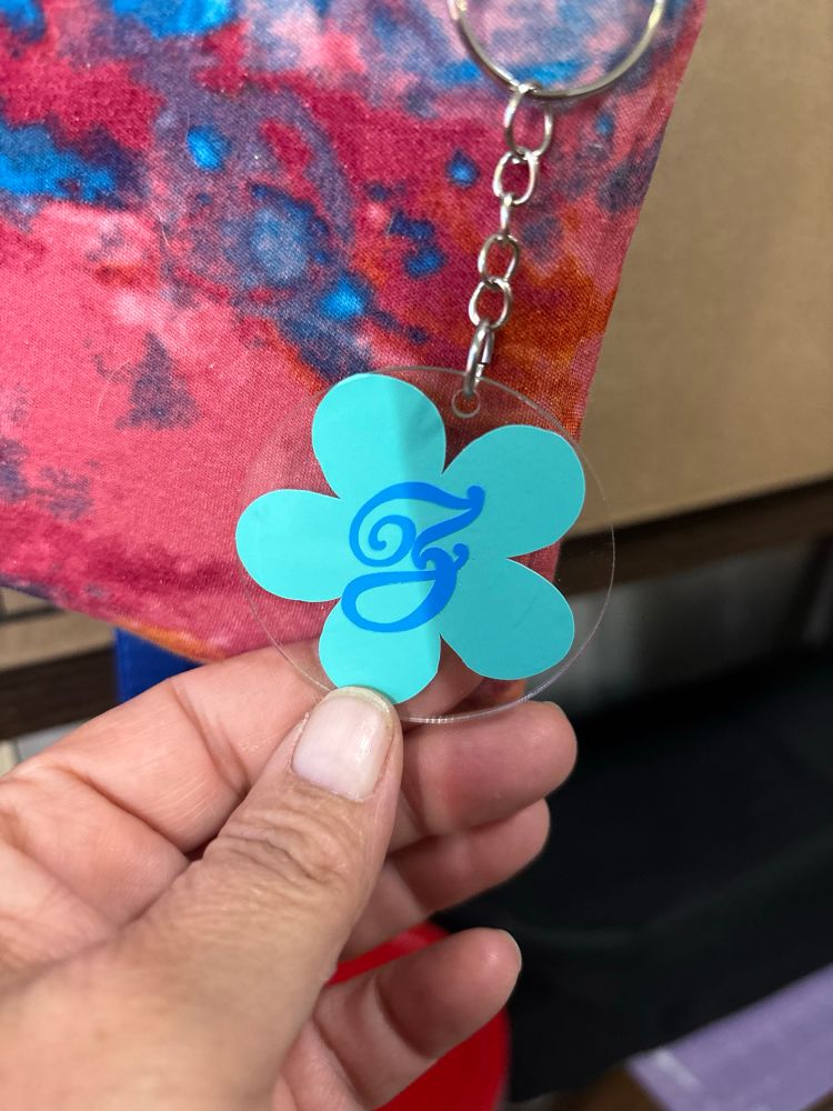 A keychain with a Z initial and a green flower behind it   