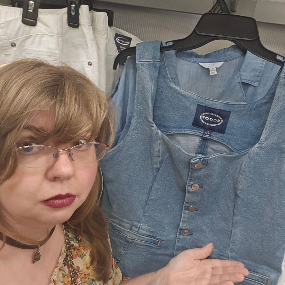 Blonde lady presenting a denim jean vest. 