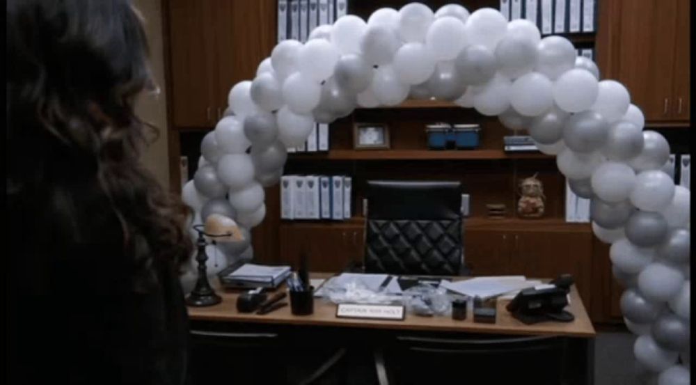 a woman stands in front of a desk that has a name tag that says ' captain smith ' on it