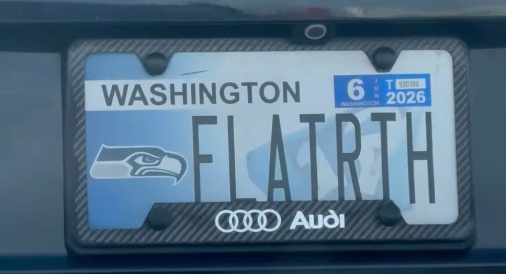 A Seahawks logo license plate that says FLATRTH