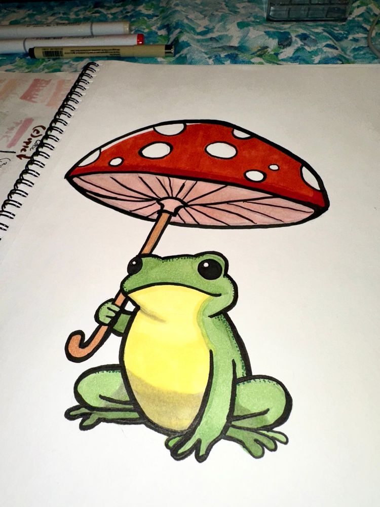 A green cartoon frog with a yellow belly and beady black eyes holding a bright red and white-spotted toadstool as an umbrella 