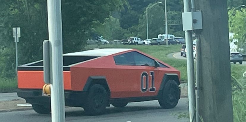 A Tesla Cybertruck painted orange with an “01” on the side, like the Dukes of Hazzard’s “General Lee.”