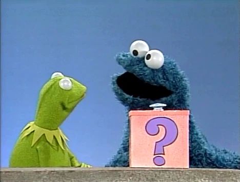 Kermit and Cookie Monster in front of a blue background.