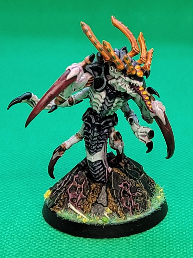 Tremorscythe Ravener Tyranid. It is mostly white/pink and red/purple colors with some head appendages that are orange. 