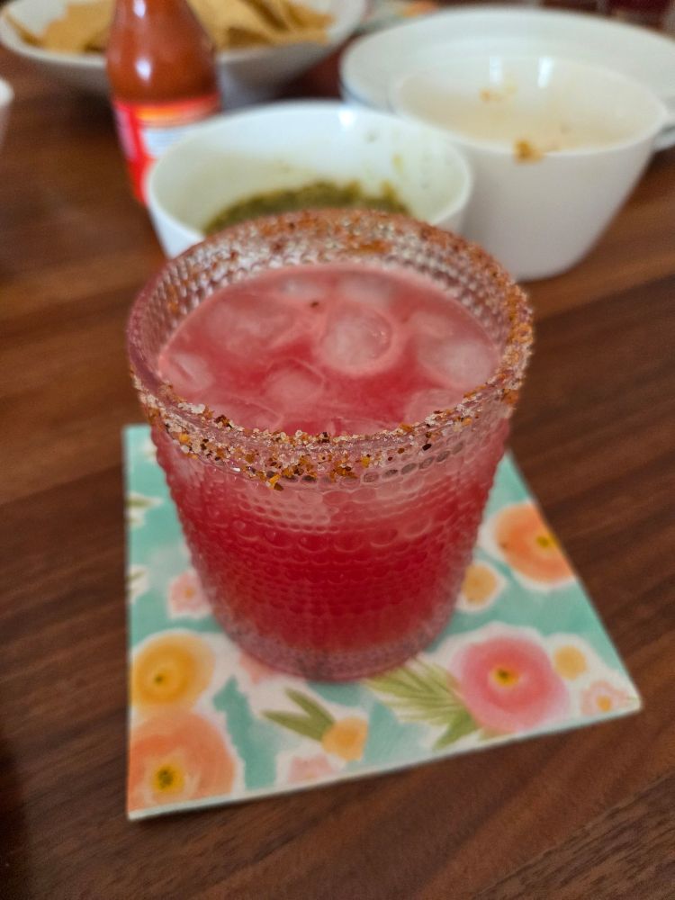 Beaded glass on a napkin filled with pinkish  Margarita