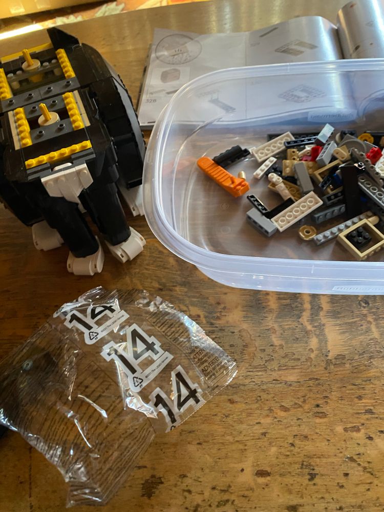 Half finished Lego cat with tub of Lego pieces 