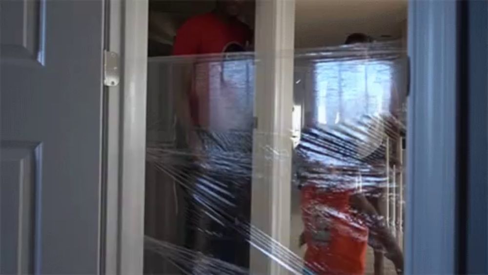 a door is covered in plastic wrap and a person is standing in the doorway