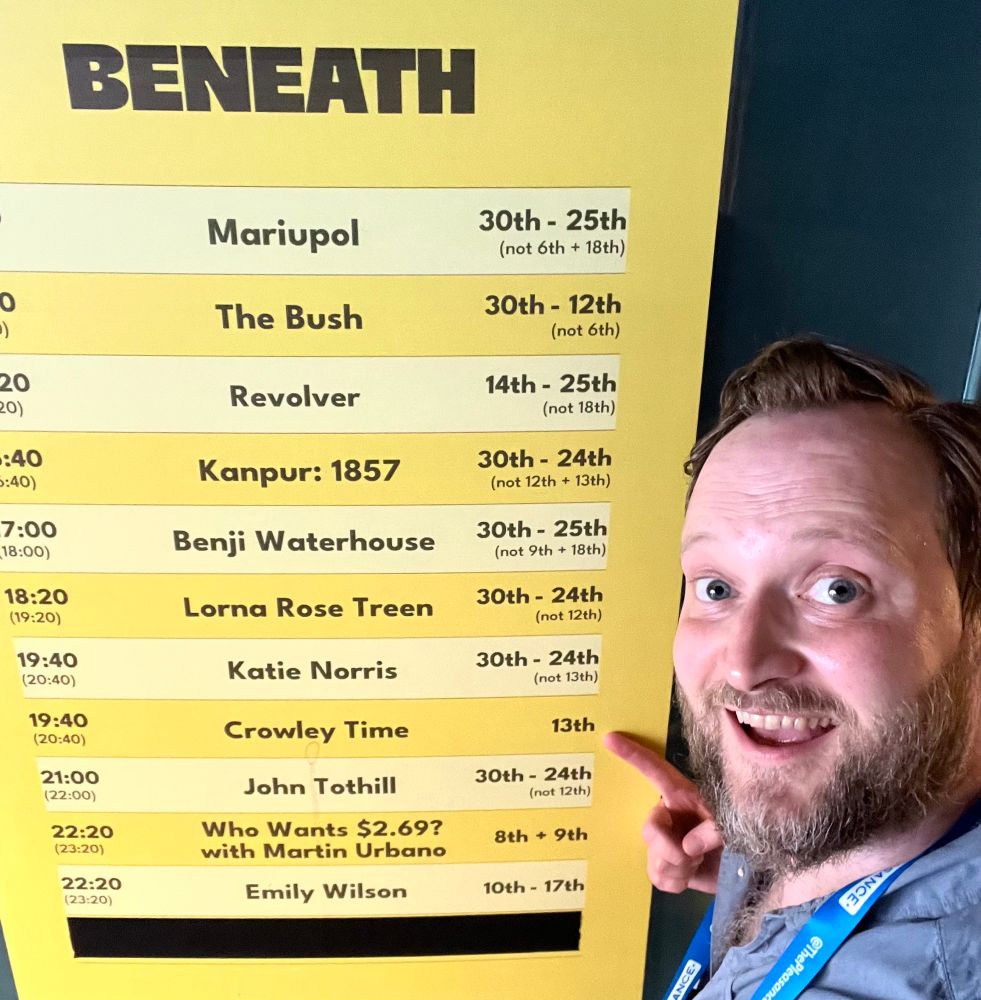 Me, Tom Crowley, standing in front of the listings board for the Pleasance Courtyard’s Beneath venue. I am pointing at the entry for 19:40 on the 13th August: Crowley Time.