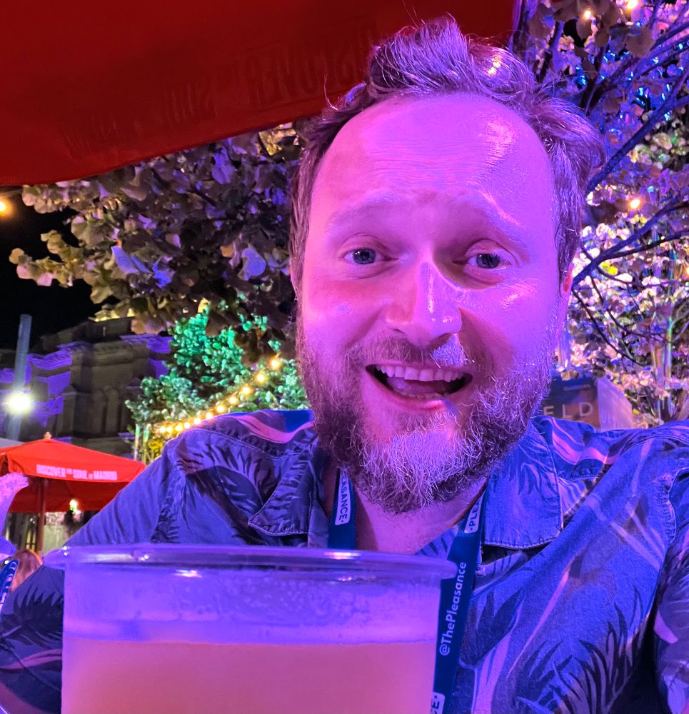 Me, Tom Crowley, looking sweaty and tired in a beer garden sitting behind a big beer. 