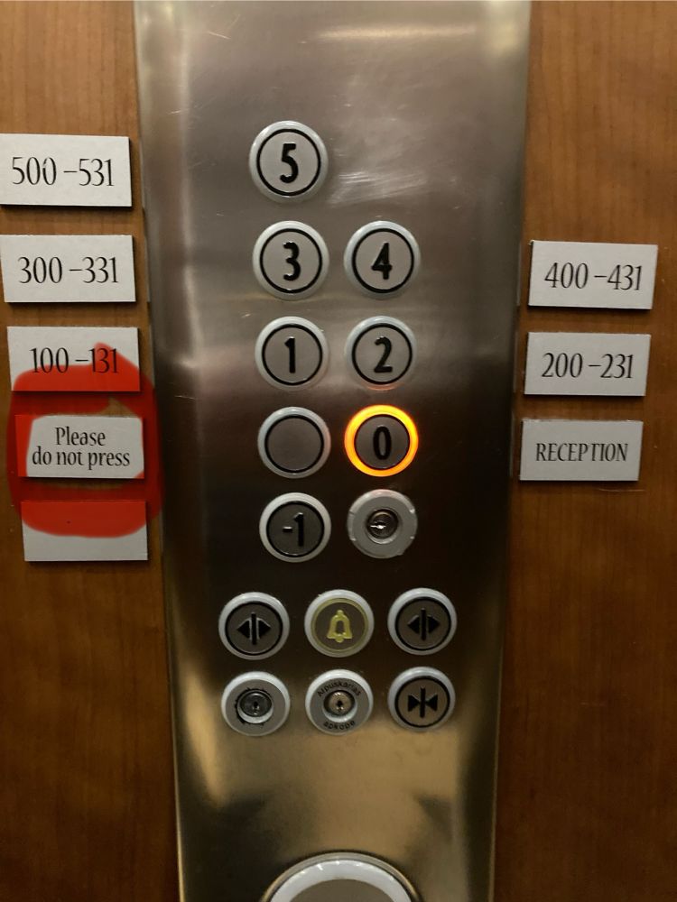 Tasten in einem Hotel-Lift. Alle sind mit Stockwerks- und Zimmernummern beschriftet, nur eine mit „Please do not press“