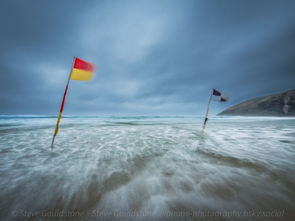 Lifeguard flags on Mawgan Porth, Cornwall. 

Stormy - 50mph winds and rain. Still a favourite place no matter what the weather.

No suncream required today! 

Long exposure mode on iPhone to capture the waves and flags blowing in the wind.