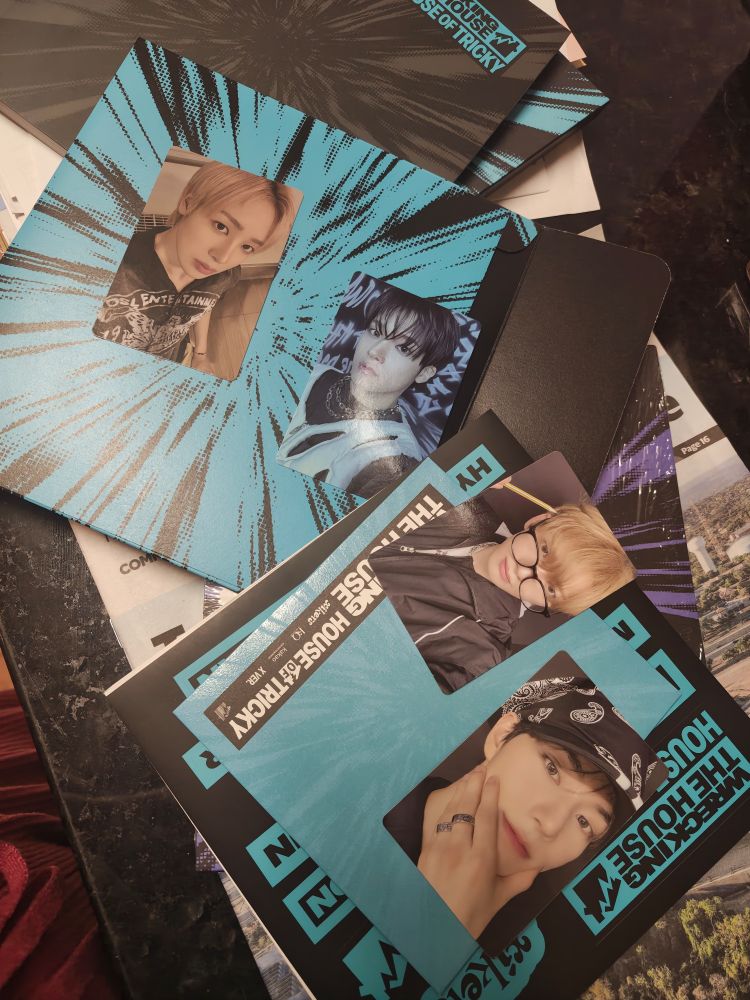 Spread of album materials showing photo cards of kpop group xikers. From left: Hunter, Junmin, Minjae, Jinsik
