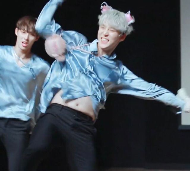 Jeong Yunho (ATEEZ) wearing a silky blue shirt and pants, smiling widely and wearing cow ears, dancing