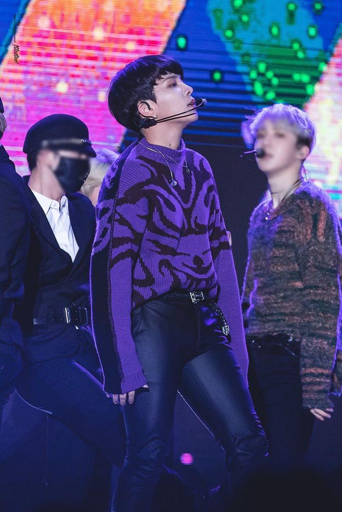 Choi Jongho (ATEEZ) standing on stage wearing black pleather pants and a purple sweater