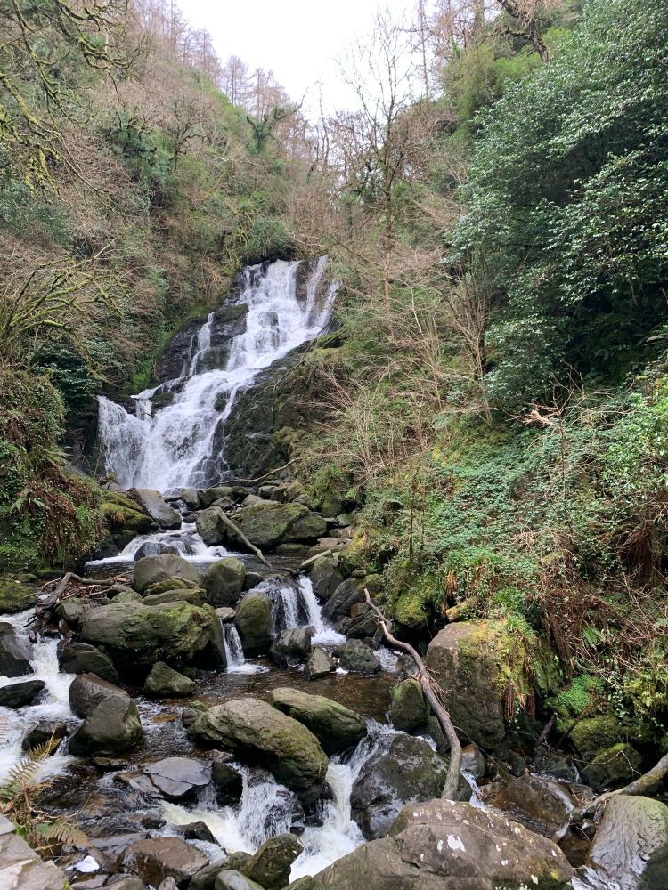 a small waterfall flowing over rocks at killarney national park in ireland