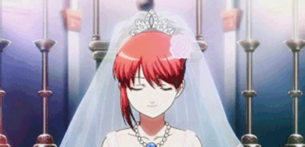 a girl with red hair is wearing a wedding dress and veil .