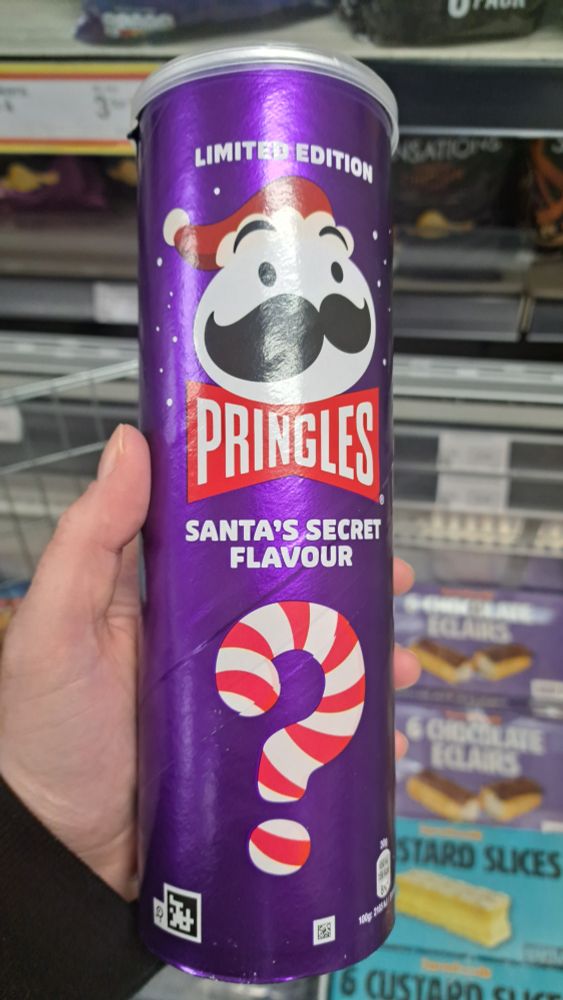 my hand holding a purple can of pringles - santa's secret flavour.