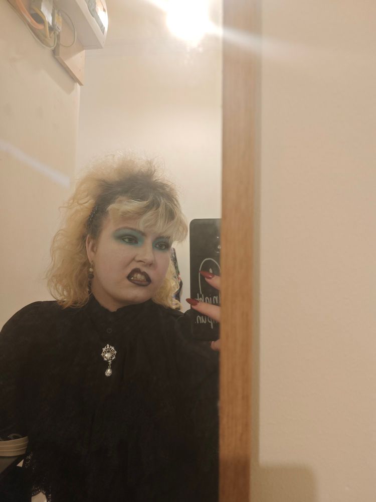 a photo of me with teased up hair and 80s style goth makeup