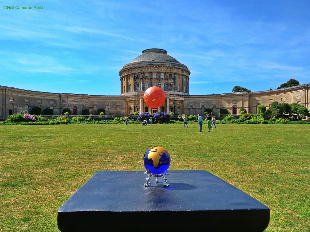 Taken on the lawn in front of the main entrance. The central rotunda stands proud in the centre of the façade with it's wings stretching out beyond either side of the picture.
In front of the entrance a temporary art installation called 'Helios' by Luke Jerram representing the Sun hangs from a cradle (it's about 8m in diameter). In the foreground a tiny blue glass orb with the continents picked out in gold represents the distance from the Earth to the Sun.
The art installation would probably look very good at twilight as it is illuminated... at the time of our visit we found it decidedly 'meh !'
