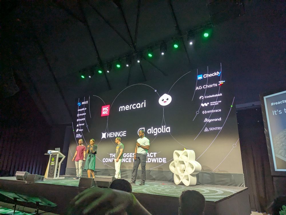 Emcees on stage introducing react summit